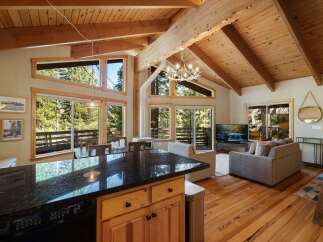Experience mountain living in this stunning home featuring a spacious open-concept living area with vaulted wood-beamed ceilings and abundant natural light.