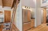 Discover rustic charm in this inviting space featuring a unique wooden ladder leading to a loft area, perfect for maximizing space.
