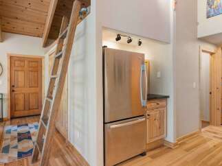 Discover rustic charm in this inviting space featuring a unique wooden ladder leading to a loft area, perfect for maximizing space.