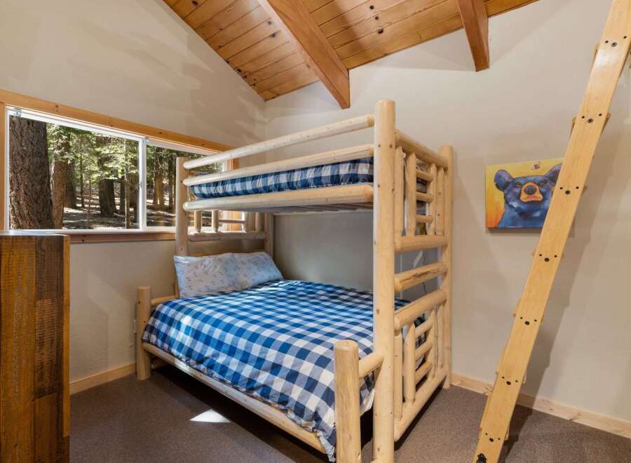 Experience rustic charm in this cozy cabin bedroom, featuring a sturdy log bunk bed perfect for families or groups.