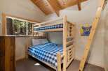 Experience rustic charm in this cozy cabin bedroom, featuring a sturdy log bunk bed perfect for families or groups.
