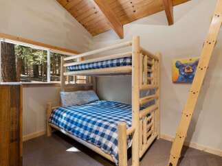Experience rustic charm in this cozy cabin bedroom, featuring a sturdy log bunk bed perfect for families or groups.