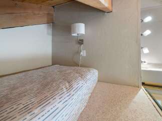This cozy loft space features a comfortable bed with a striped duvet, perfect for a relaxing retreat.