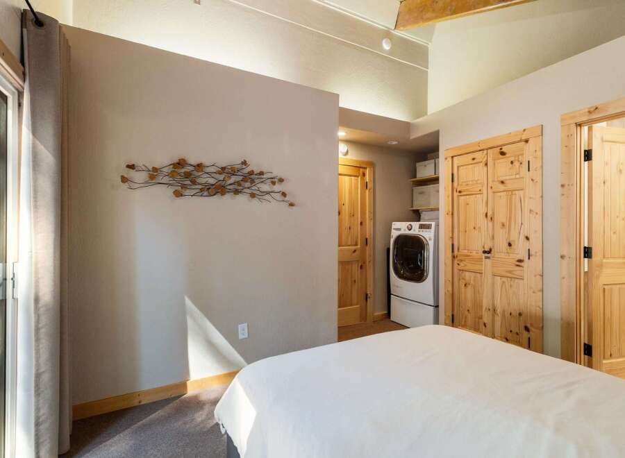 This bedroom offers a convenient in-room laundry setup with a modern washer and dryer.