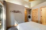 This bedroom offers a convenient in-room laundry setup with a modern washer and dryer.