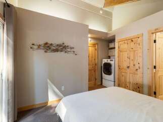 This bedroom offers a convenient in-room laundry setup with a modern washer and dryer.