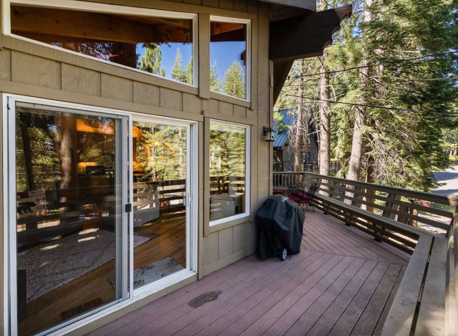 Enjoy outdoor living on this spacious deck, perfect for entertaining or relaxing amidst the serene forest setting.