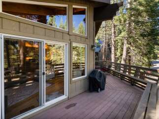 Enjoy outdoor living on this spacious deck, perfect for entertaining or relaxing amidst the serene forest setting.