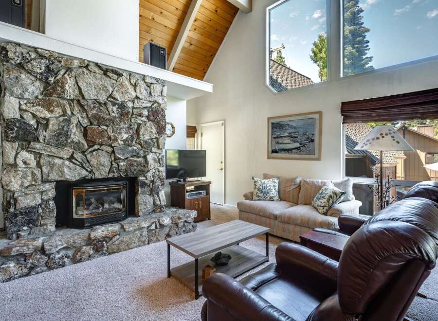 Experience cozy living in this charming mountain retreat, featuring a magnificent floor-to-ceiling stone fireplace as the centerpiece of the living room.