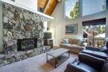 Experience cozy living in this inviting living room, featuring a magnificent floor-to-ceiling stone fireplace that serves as the heart of the space.