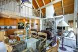 Experience spacious living in this open-concept home featuring a stunning stone fireplace and a vaulted wood-beamed ceiling.