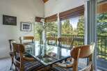 Dine with a view in this elegant dining room featuring a glass-top table and unique wooden chairs.