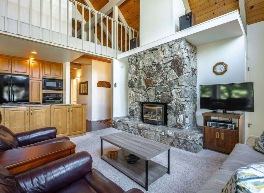 Experience the cozy charm of this mountain retreat, featuring a stunning floor-to-ceiling stone fireplace as the centerpiece of the living area.