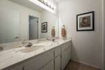 This bathroom features a spacious double vanity with a marble countertop and two undermount sinks, perfect for busy mornings.