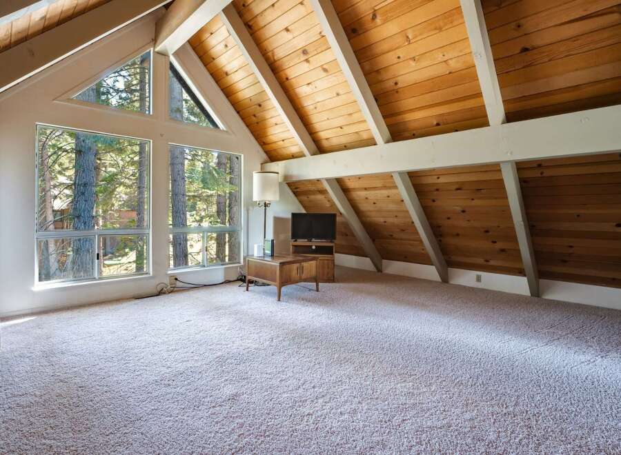 Experience breathtaking natural beauty from this stunning living space, featuring expansive windows that frame the surrounding forest.