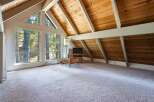 Experience breathtaking natural beauty from this stunning living space, featuring expansive windows that frame the surrounding forest.