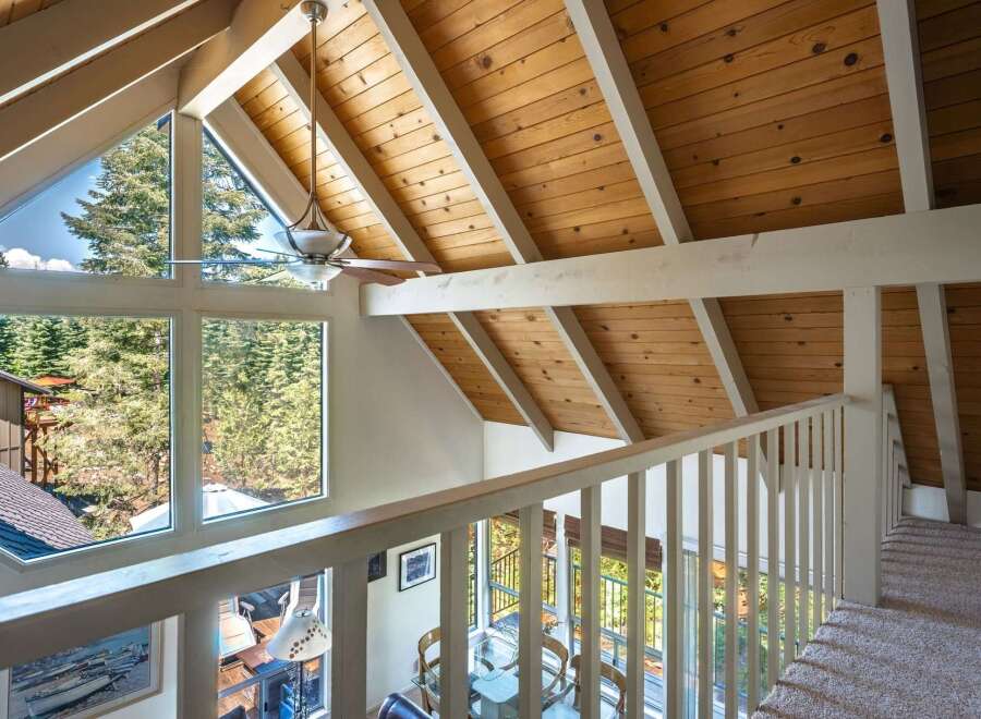 Experience breathtaking views from this stunning property, featuring a vaulted wood-paneled ceiling and expansive windows that flood the space with natural light.