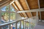 Experience breathtaking views from this stunning property, featuring a vaulted wood-paneled ceiling and expansive windows that flood the space with natural light.