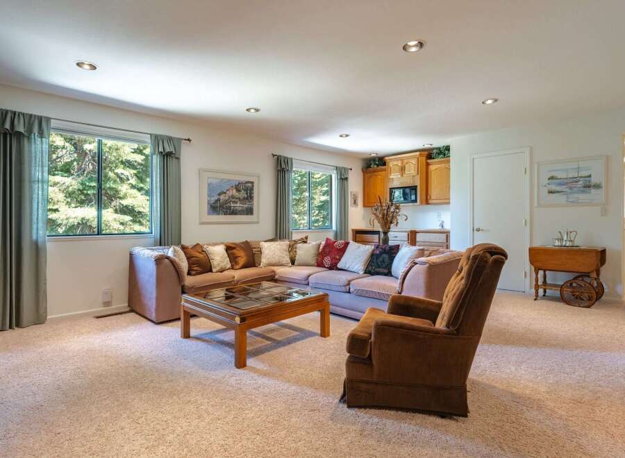This spacious living area features a large sectional sofa and a comfortable armchair, perfect for relaxing.