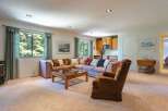 This spacious living area features a large sectional sofa and a comfortable armchair, perfect for relaxing.