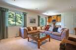 This spacious living area features a large sectional sofa perfect for gatherings, complemented by a stylish wooden coffee table with a glass top.