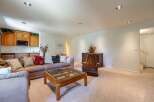 This spacious living area features a comfortable sectional sofa and a plush armchair, perfect for relaxation.