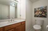 This charming bathroom features a spacious vanity with a marble countertop and a wooden cabinet, perfect for storage.