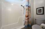 This bathroom features a clean white bathtub and shower combo, perfect for relaxing after a long day.