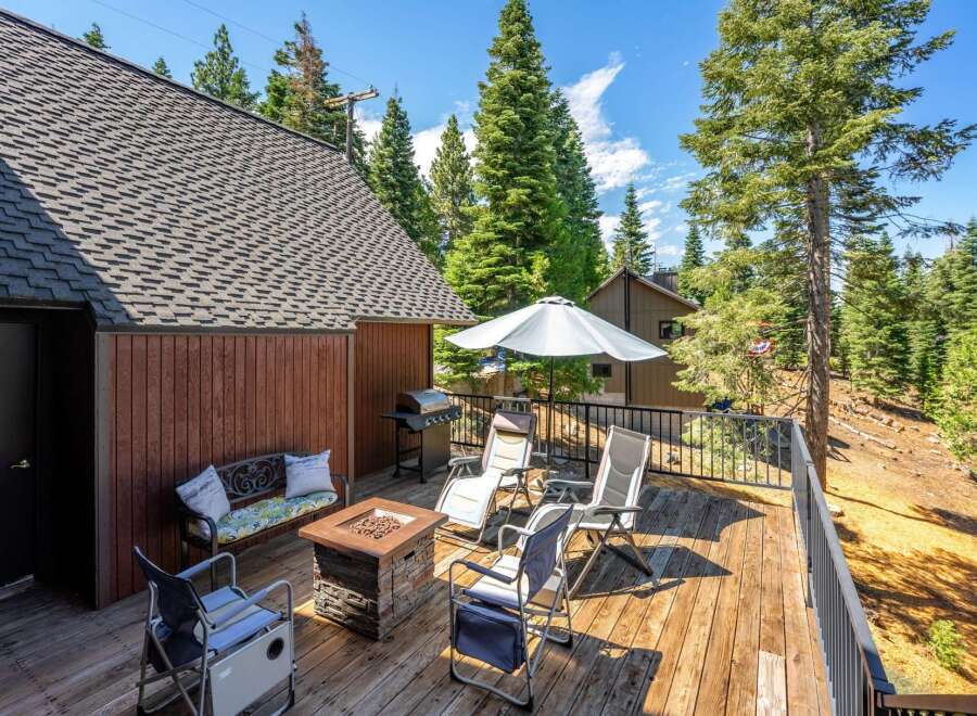 Enjoy outdoor living on this spacious wooden deck, complete with a gas grill, fire pit, and comfortable seating.
