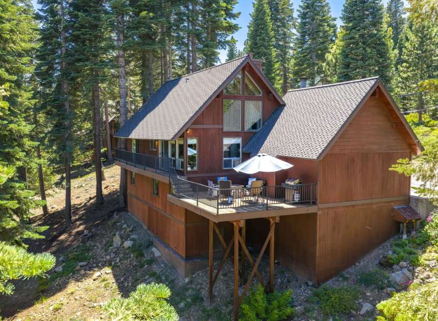 Nestled amidst towering pine trees, this charming wooden cabin offers a serene mountain retreat.