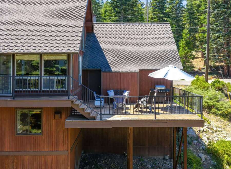 Enjoy outdoor living on this spacious deck, complete with a grill and seating area, perfect for entertaining.