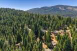 Nestled amidst a dense forest of towering evergreen trees, this property offers a serene and private mountain retreat.
