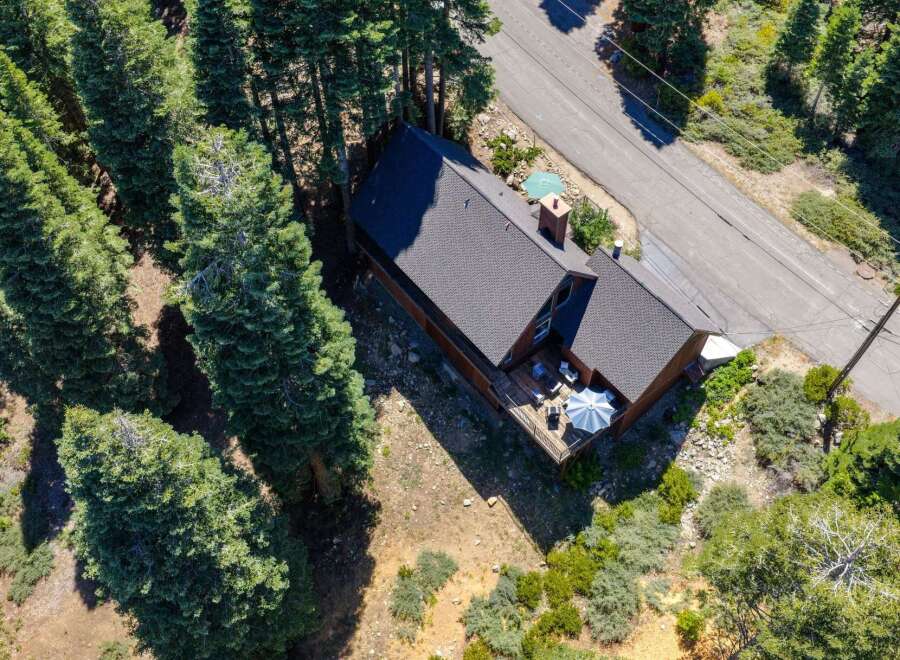 Nestled amidst tall evergreen trees, this charming home offers a serene mountain retreat.