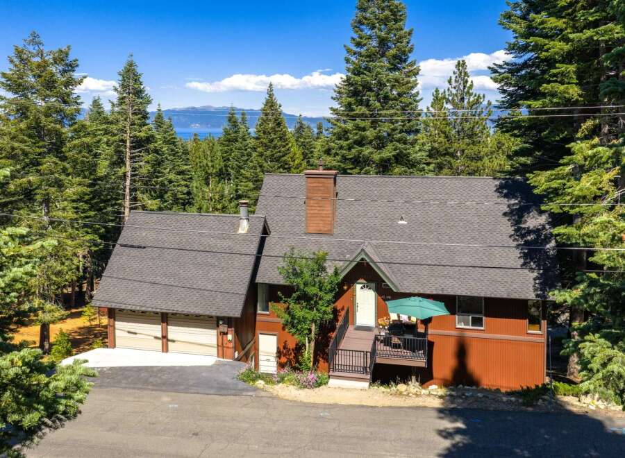 Nestled amidst towering pine trees with a stunning lake view, this charming mountain home offers a serene escape.