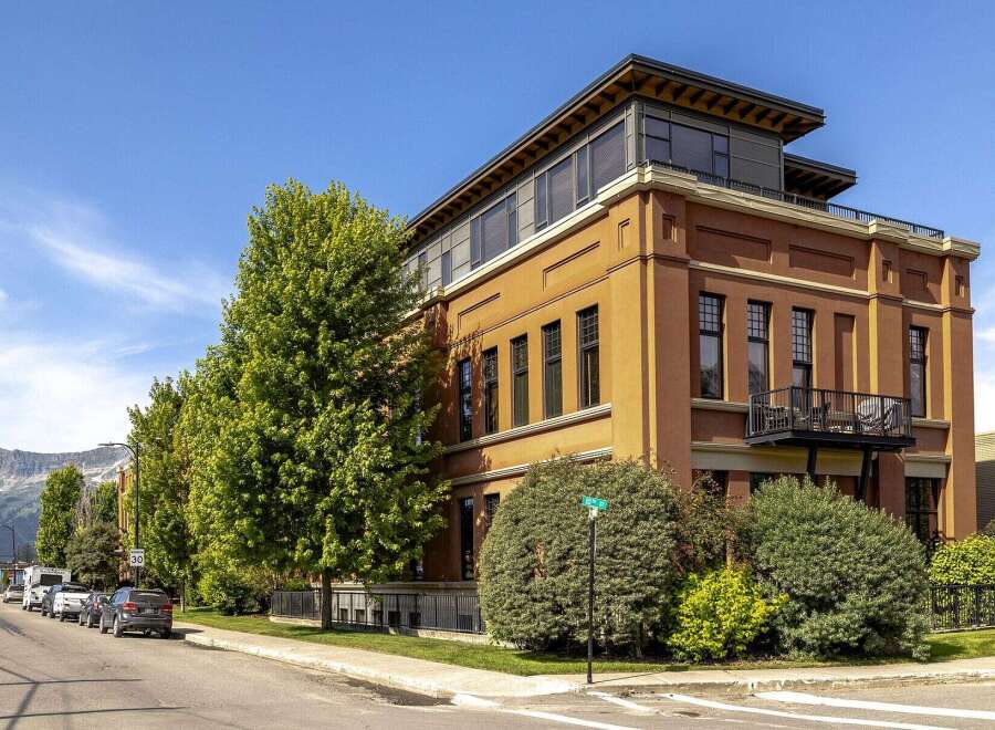 Experience urban living in this stunning multi-story building featuring a striking terracotta facade and a modern rooftop addition.