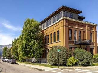 Experience urban living in this stunning multi-story building featuring a striking terracotta facade and a modern rooftop addition.