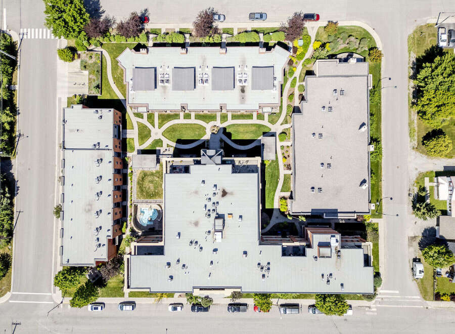 Discover this stunning aerial view of a modern apartment complex featuring multiple buildings with flat roofs and numerous HVAC units.