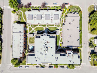Discover this stunning aerial view of a modern apartment complex featuring multiple buildings with flat roofs and numerous HVAC units.