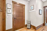 This inviting entryway features a beautiful solid wood door with a modern black handle, complemented by intricate wood trim.