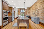 Experience industrial-chic living in this stunning kitchen featuring exposed brick walls and warm wood cabinetry.