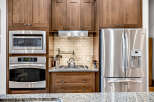 Experience modern convenience in this kitchen featuring stainless steel appliances, including a built-in microwave, oven, and a spacious side-by-side refrigerator with an ice dispenser.