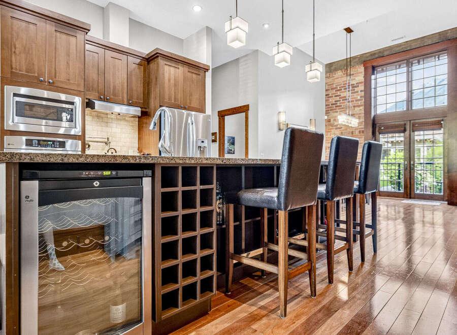 Experience luxury living in this stunning kitchen featuring rich wood cabinetry and a sleek granite countertop.