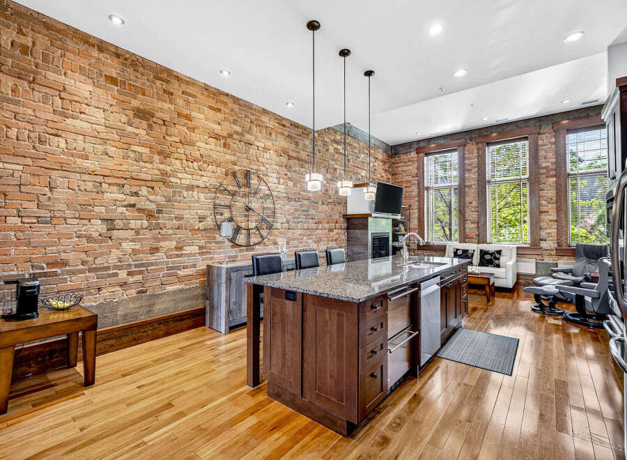 Experience urban living in this stunning loft featuring exposed brick walls and gleaming hardwood floors.