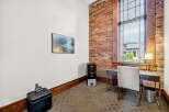 This office space features a large window with blinds, offering ample natural light and a view of the outdoors.