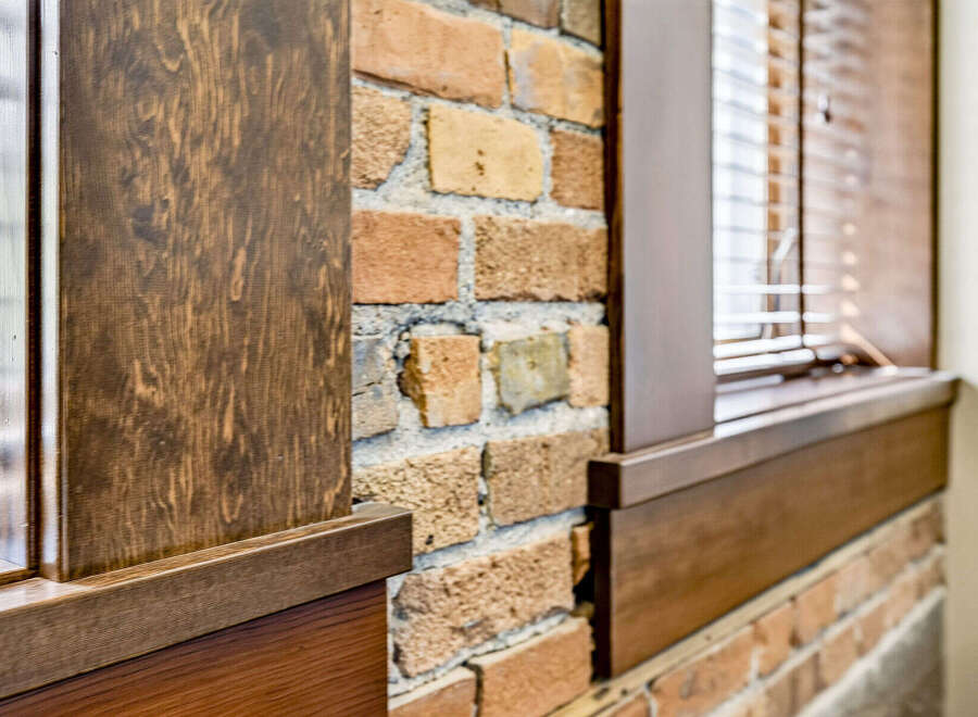 Experience rustic charm with this exposed brick wall, complemented by rich wooden accents.