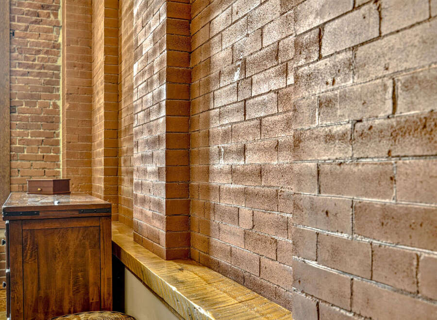 Exposed brick walls add a rustic charm and architectural interest to this space, creating a warm and inviting atmosphere.