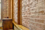 Exposed brick walls add a rustic charm and architectural interest to this space, creating a warm and inviting atmosphere.