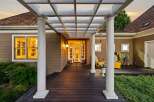 Step into this charming home through a welcoming covered porch featuring a white pergola and elegant columns.