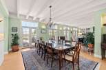 Experience elegant dining in this spacious room, featuring a large glass-top table surrounded by classic wooden chairs.