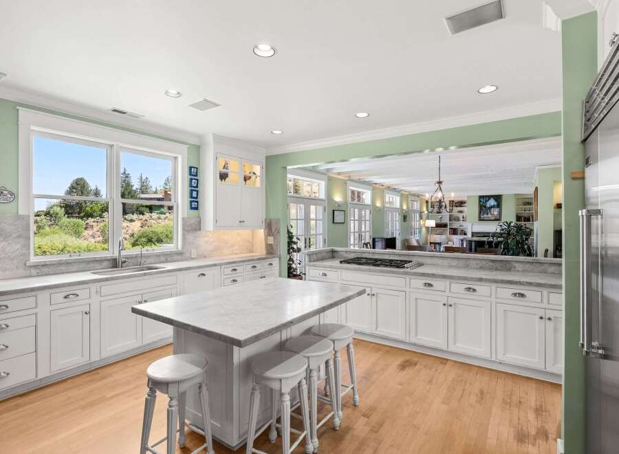 Experience the best of indoor-outdoor living in this stunning kitchen, featuring a large island with seating and ample counter space.